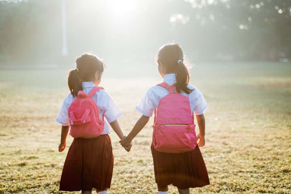 Back to school two little girls walking hand in hand