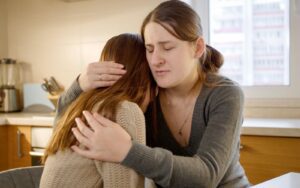 A parent hugging their child due to the loss of a loved one