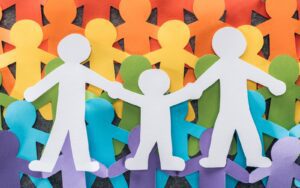 Cut out paper people in rainbow colours standing for LGBT+ Sexuality and Gender