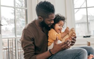 Father and child playing with wooden toy